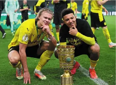  ?? — Reuters ?? Dynamic duo: Borussia dortmund’s Erling Braut Haaland (left) and Jadon Sancho celebratin­g with the trophy after winning the German Cup final.