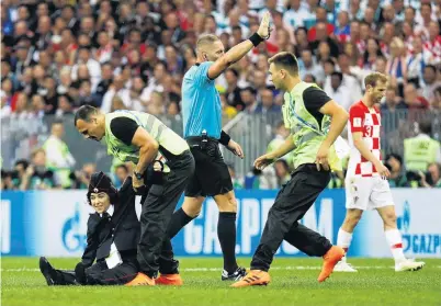  ?? PHOTO: GETTY IMAGE ?? Brought down . . . Stewards apprehend a pitch invader as referee Nestor Pitana stops play during the World Cup final at Luzhniki Stadium, in Moscow, yesterday.