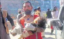  ?? AP ?? A volunteer carries an injured child to a hospital in Peshawar after the attack on Tuesday.