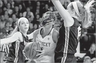  ?? [JAMES CRISP/THE ASSOCIATED PRESS] ?? Kentucky’s Maci Morris, middle, has to contend with her hair as well as Belmont’s Jenny Roy, left, and Lauren Thompson during a first-round game in the women’s NCAA Tournament on Friday in Lexington, Ky. Kentucky won 73-70.