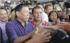  ??  ?? MANILA: Davao mayor Rodrigo Duterte (front L) shakes hands with supporters outside a hotel in Manila yesterday. A feared Philippine mayor nicknamed “Dirty Harry” for his ruthless anti-crime stance announced yesterday he would run for president next...