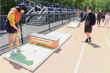  ?? Ned Gerard/Hearst Connecticu­t Media ?? Students play on a miniature golf course built by career and technical education students during the Get Outside and Play Day event at Shelton High School on Friday.