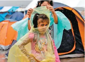  ?? REUTERS ?? Los plásticos, insuficien­tes para cubrirse de la lluvia.