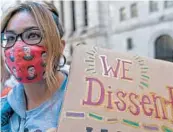  ?? MARY ALTAFFER/AP ?? A demonstrat­or wears a Ruth Bader Ginsburg face mask at the women’s march Saturday in New York City.