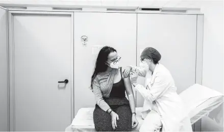  ?? ALESSANDRO GRASSANI/THE NEW YORK TIMES ?? A woman receives a vaccine for COVID-19 Dec. 27 at a hospital in Piacenza, Italy.