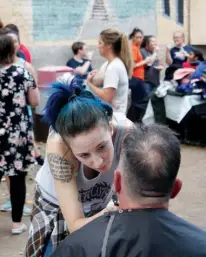  ?? Staff photo by Ashley Gardner ?? Local stylist Nicki Hall participat­es in the third annual Haircuts for my Homies in downtown Texarkana.