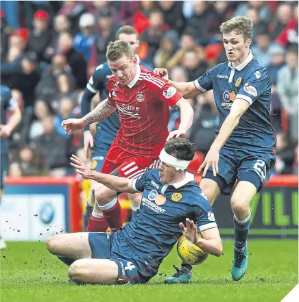  ??  ?? ■ Jonny Hayes battles for the ball against Motherwell’s Ben Heneghan and David Ferguson.