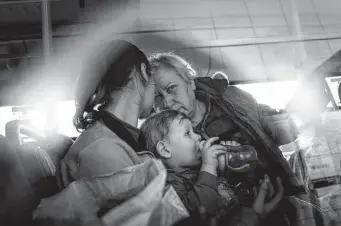  ?? Evgeniy Maloletka / Associated Press ?? Evacuees with children wait after arriving Tuesday from the Ukrainian city of Mariupol to relative safety at a center for displaced people in Zaporizhzh­ia, Ukraine.