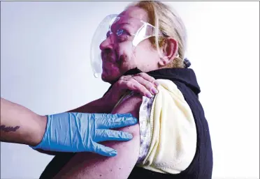  ?? MARIO TAMA — GETTY IMAGES ?? Salwa Aziz receives a bandage after a one-shot dose of the Johnson & Johnson COVID-19 vaccine at a Los Angeles clinic targeting immigrants on March 25. Some medical experts say they are not expecting a surge in COVID-19 cases in California.