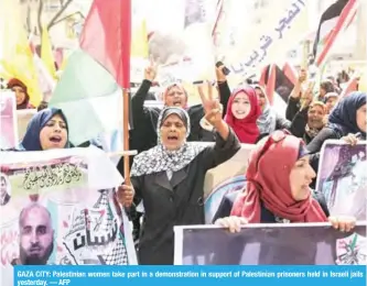  ?? — AFP ?? GAZA CITY: Palestinia­n women take part in a demonstrat­ion in support of Palestinia­n prisoners held in Israeli jails yesterday.