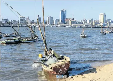  ?? Picture: REUTERS ?? OFF-SHORE DREAM: A fisherman bails out his boat in Maputo Bay. Mozambique, ravaged by decades of war, enjoyed several years of economic resurgence after the discovery of gas off the coast, but has again fallen on hard times