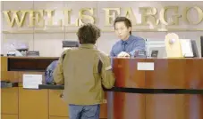  ?? — Reuters ?? Bank Teller Tyler Wong talks to a customer at the Wells Fargo bank in Denver, Colorado, US.