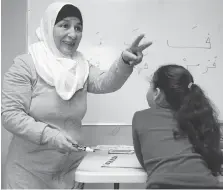  ??  ?? Ghaithaa Sabak, left, teaches Arabic and religion at the Syrian Community Centre on Ottawa Street.