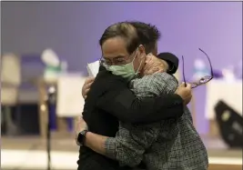 ?? JAE C. HONG — THE ASSOCIATED PRESS ?? Jason Aguilar, left, a senior pastor at Arise Church, comforts Billy Chang, a 67-year-old Taiwanese pastor who survived Sunday’s shooting at Geneva Presbyteri­an Church, during a prayer vigil in Irvine on Monday.