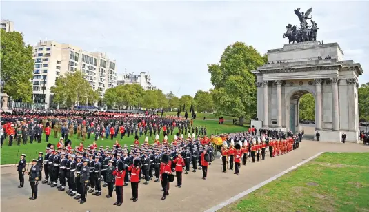  ?? ?? A job for the Navy: Her Majesty’s coffin is drawn forward by ropes through Wellington Arch