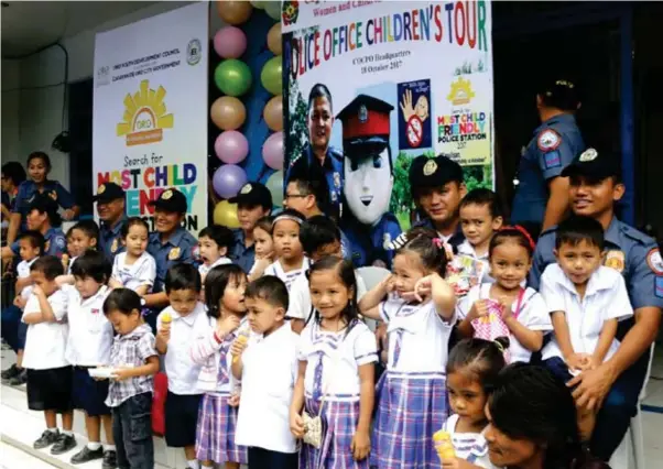  ?? (JOEY P. NACALABAN) ?? BESTIES. Several school children are entertaine­d by police officers during yesterday's children's tour at the Cagayan de Oro City Police Office (COCPO). The event was in connection with the city's annual search for the ‘most child-friendly' police...