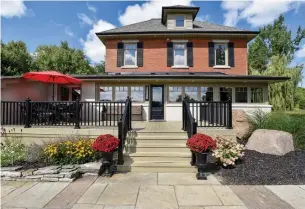  ?? CENTURY 21 MILLENNIUM PHOTOS ?? The all-brick, 2-1/2-storey home features exterior shutters and a stone walkway to the main entrance that also features a stone patio, large deck and perennial gardens.