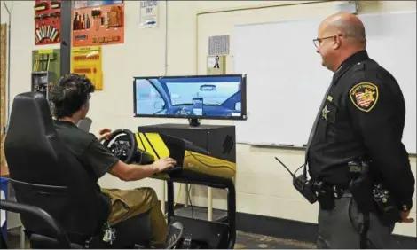  ?? SUBMITTED ?? Bryce O’Neal, JVS Industrial Electricit­y senior, operates the driving simulator was Deputy Anthony Pluta observes.