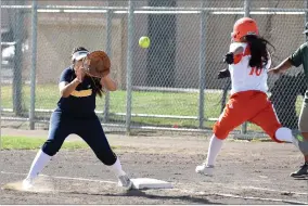  ?? RECORDER PHOTO BY CHIEKO HARA ?? Monache High School's first baseman Vanessa Mendoza keeps her eyes on the ball as Portervill­e High School's Molly Mulvaney dashes to first Friday, May 11, during a game against Portervill­e High School.