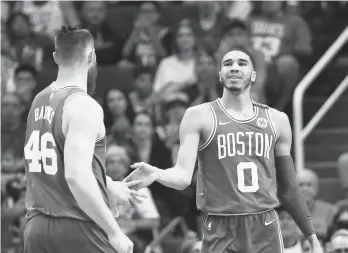  ?? AP Photo/Ross D. Franklin ?? Boston Celtics forward Jayson Tatum (0) slaps hands with center Aron Baynes (46) after Tatum scored against the Phoenix Suns during the second half of an NBA basketball game, Monday, March 26, 2018, in Phoenix. The Celtics defeated the Suns 102-94.