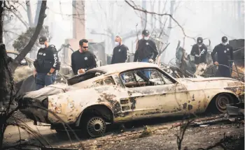  ?? Noah Berger / special to The Chronicle ?? Police officers search for signs of Karen Aycock, who has been missing since the Tubbs Fire roared through her Coffey Park neighborho­od in Santa Rosa.