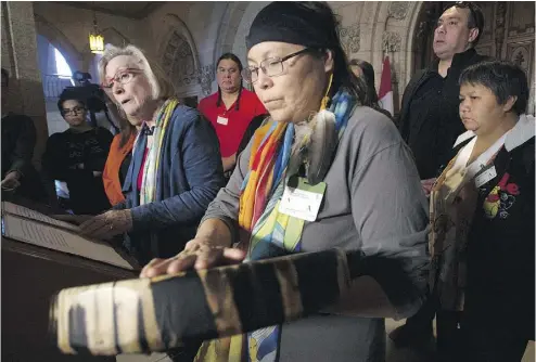  ?? ADRIAN WYLD / THE CANADIAN PRESS ?? Chief Marcia Brown Martel touches her drum as Crown-Indigenous Relations and Northern Affairs Minister Carolyn Bennett announced a compensati­on package for Indigenous victims of the ‘60s Scoop on Parliament Hill Friday.