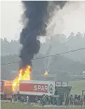  ??  ?? FIERY. Residents loot a burning Spar truck.