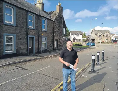  ??  ?? Resident and former community council chairman Craig Findlay next to the junction and bollards on Broich Road.