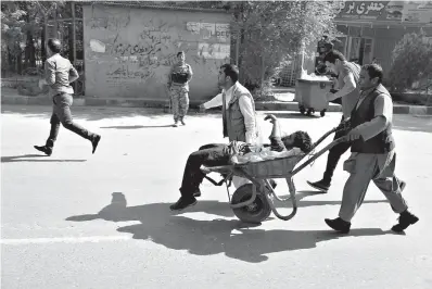  ?? AP Photo/Rahmat Gul ?? ■ Afghan men carry a wounded man after the second blast Monday in Kabul, Afghanista­n. A coordinate­d double suicide bombing hit central Kabul on Monday morning, killing at least 25 people.