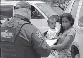  ?? AP PHOTO ?? A mother migrating from Honduras holds her one-year-old child while surrenderi­ng to U.S. Border Patrol agents after illegally crossing the border near Mcallen, Texas.