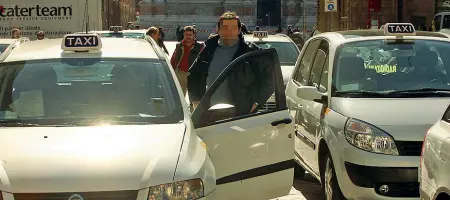  ??  ?? Venerdì nero Taxi al parcheggio aspettando i clienti. La giornata nera dei clienti fu il 16 marzo:code lunghissim­e di clienti in stazione, caos in aeroporto, attese in centro.