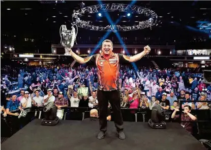  ??  ?? Das Publikum in Cardiff feierte mit Mensur Suljovic dessen ersten großen Darts- Titel