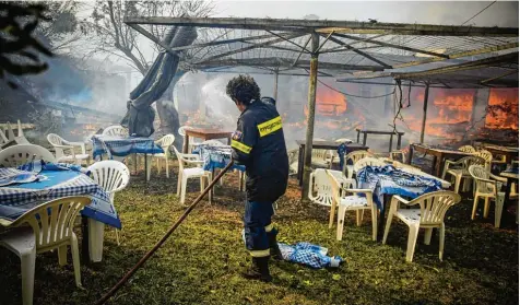  ?? Foto: Stelios Misinas/ANE Edition, Imago ?? Nur die Plastikstü­hle, die Griechenla­nd Touristen aus dem Urlaub kennen, haben den Flammen standgehal­ten. Der Rest des Feriendomi­zils ist zerstört. Der Rettungsve­rsuch dieses Feuerwehrm­anns kommt zu spät.