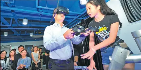 ?? ZHENG SHUAI / FOR CHINA DAILY ?? An executive from internet giant Tencent Holdings Ltd experience­s a pilot virtual reality device at an entreprene­urship event in Fuzhou, East China’s Fujian province.