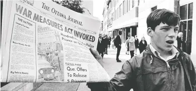  ?? PETER BREGG / THE CANADIAN PRESS FILES ?? A newsboy holds up a newspaper with a banner headline reporting the invoking of the War Measures Act in 1970.