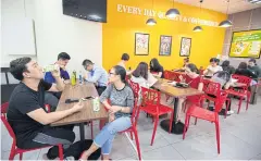  ??  ?? Customers dine at a 7-Eleven store in Ho Chi Minh City.