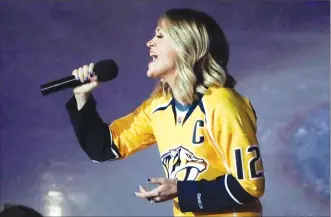  ?? Associated Press photo ?? In this April 17 file photo, country music star Carrie Underwood performs the national anthem before Game 3 of a first-round NHL hockey playoff series between the Predators and the Chicago Blackhawks, in Nashville, Tenn. Underwood is the wife of...