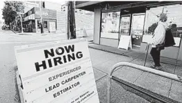  ?? ELAINE THOMPSON/AP ?? A pedestrian passes a reader board advertisin­g a job opening this month in Seattle.