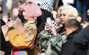  ?? — AFP ?? Singer Perry (the blonde) taking snapshots of models ono the runway for the Marc Jacobs collection during New York Fashion Week.