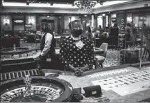  ?? MICHELE SPATARI / AFP ?? A croupier wearing a face mask and a face shield waits for clients at a roulette table at a leisure and casino complex in Johannesbu­rg, on July 3.