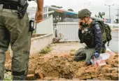  ?? JALAA MAREY/GETTY-AFP ?? An Israeli police officer inspects a rocket crater near a hospital Wednesday. The rocket was fired from southern Lebanon at Safed, northern Israel.