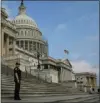  ?? MARK WILSON — GETTY IMAGES ?? A Capitol police officer stands guard in front of the United States Capitol building as the American flag flies at half staff.