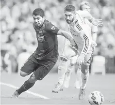  ??  ?? Barcelona’s Luis Suarez vies with Real Madrid’s Sergio Ramos during the Spanish league ‘Clasico’ match at the Santiago Bernabeu stadium in Madrid, in this Oct 25, 2014 file photo. — AFP photo