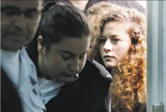  ?? Thomas Coex / AFP / Getty Images ?? Ahed Tamimi (right) enters an Israeli military court at Ofer prison in the West Bank, where she was tried for assaulting two Israeli soldiers. She settled her case to avoid more jail time.