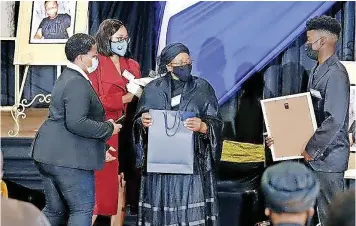  ??  ?? SLAIN Nosicelo Mtebeni’s aunt, Nomvula Beauty Gugushe receives a photograph of her niece during a memorial service at the Fort Hare University in East London yesterday