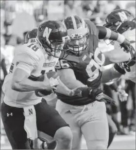  ?? Tony Ding/Associated Press ?? Northweste­rn quarterbac­k Clayton Thorson (18) tries to evade pressure from Michigan defensive lineman Ryan Glasgow (96), in the second quarter on Oct. 10 in Ann Arbor. Michigan won, 38-0.