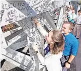  ?? RED HUBER/STAFF PHOTOGRAPH­ER ?? Disney employees Rachael and Christophe­r DeGeorge, who had a Star Wars-themed wedding last month, sign a steel beam at Star Wars: Galaxy’s Edge.