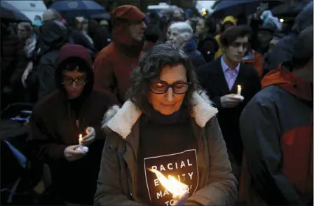  ?? MATT ROURKE — THE ASSOCIATED PRESS ?? People hold candles as they gather for a vigil in the aftermath of a deadly shooting at the Tree of Life Synagogue, in the Squirrel Hill neighborho­od of Pittsburgh, Saturday.