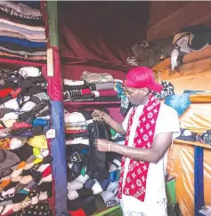  ??  ?? A seller adjusts displays at a second-hand cloths shop of Nyamirambo Market in Kigali.