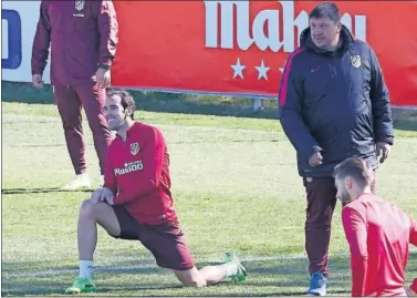  ??  ?? LISTO. Godín estirando ayer durante la sesión de entrenamie­nto ante la presencia de Burgos.